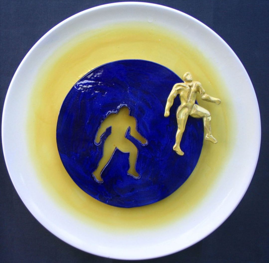Figura gialla su disco blù
